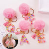 Pink fuzzy pom-pom initial letter keychains in shiny resin for bags and backpacks