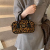 Braune Leopardenmuster-Designer-Hobo-Tasche, getragen von einer Person in einem Taupe-Blazer.