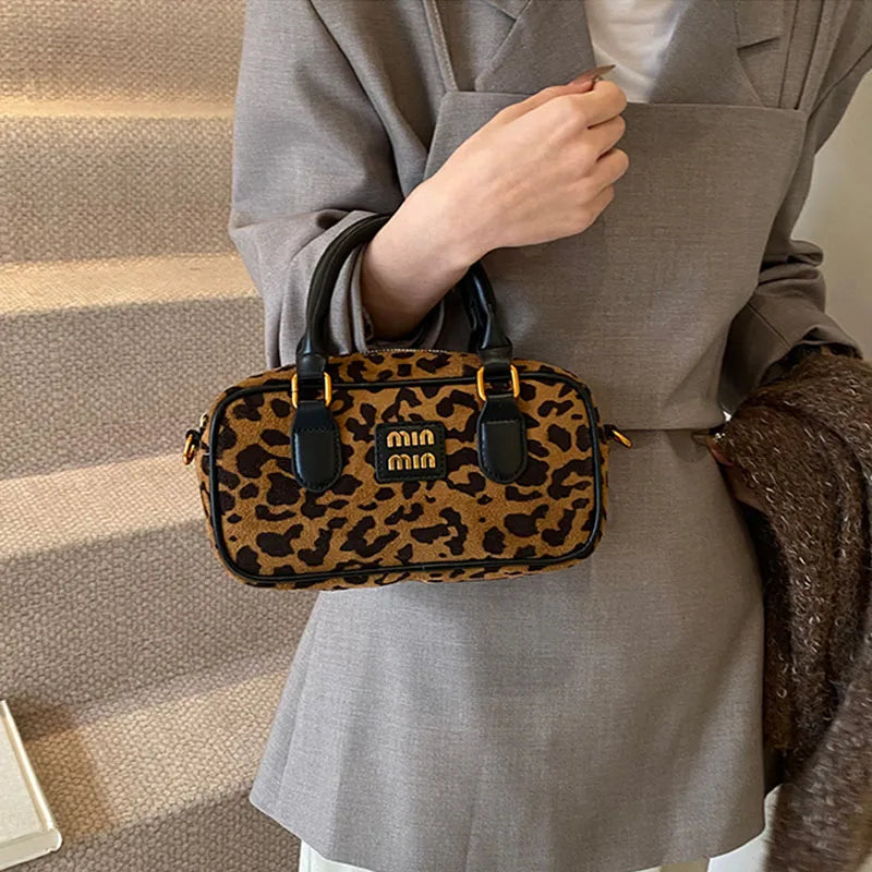 Braune Leopardenmuster-Designer-Hobo-Tasche, getragen von einer Person in einem Taupe-Blazer.