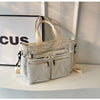 A cream textured corduroy tote bag with adjustable straps displayed on a white surface.