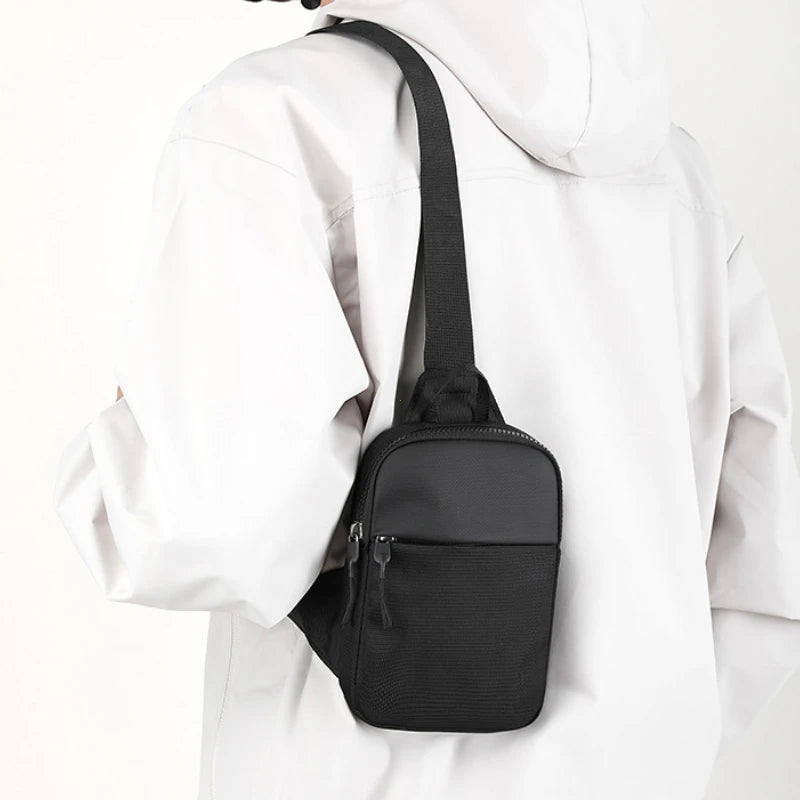 Una bolsa cruzada negra impermeable atada a una chaqueta blanca con capucha.