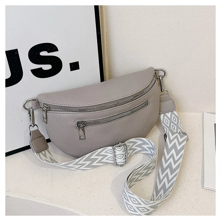 A light gray PU leather multi-pocket crossbody bag with a patterned strap is displayed on a white surface.