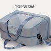 Top view of a light blue expandable nylon travel duffle bag with gray straps.