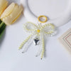 A yellow pearl bowknot keychain with a silver heart charm and gold-colored ring.