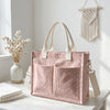 Sac cabas à pois roses en velours côtelé avec poignées beige clair, exposé sur une surface en bois blanc.