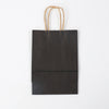 A dark brown reusable kraft paper gift bag with natural twine handles.