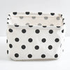 A white storage basket with black polka dots, made of foldable cotton linen, shown from above.