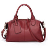 A deep red leather tote bag with a zipper closure and adjustable shoulder strap.