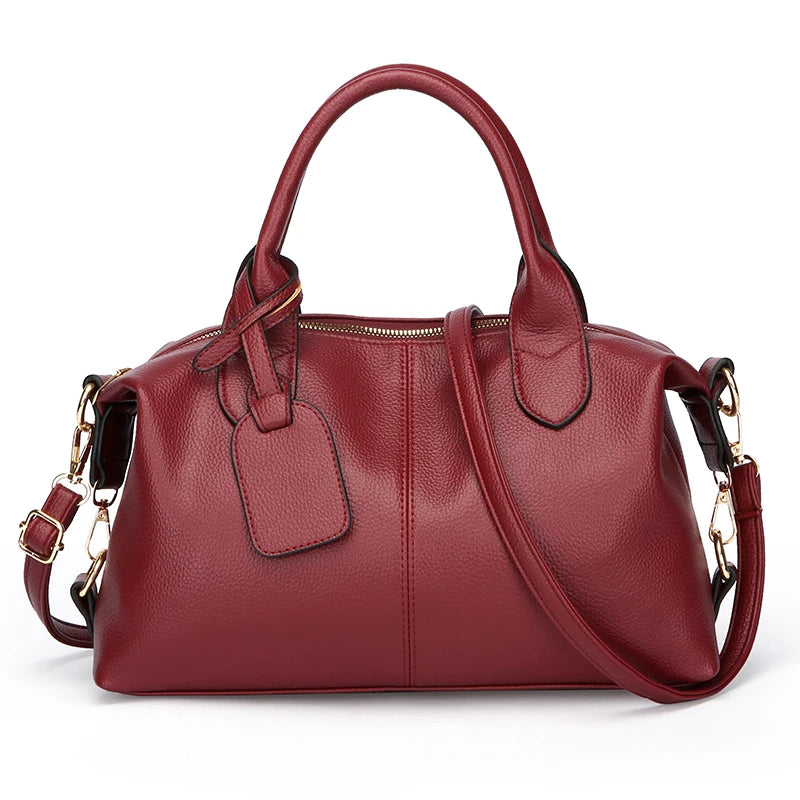 A deep red leather tote bag with a zipper closure and adjustable shoulder strap.