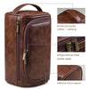 A brown leather toiletry bag with a reinforced handle, featuring antique bronze metal zippers and an adhesive bone support.