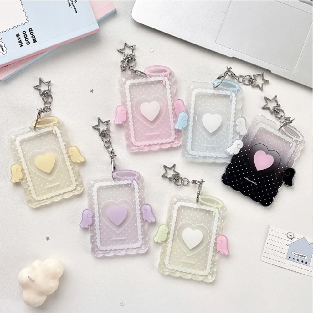 A collection of clear and pastel acrylic photocard holders with heart shapes and angel wings on a white background.