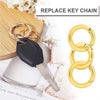 A set of gold-colored key chains and metal key rings displayed next to a key.