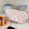 Pink rose sweetheart cosmetic storage pouch with white lace trim resting on a pink surface.