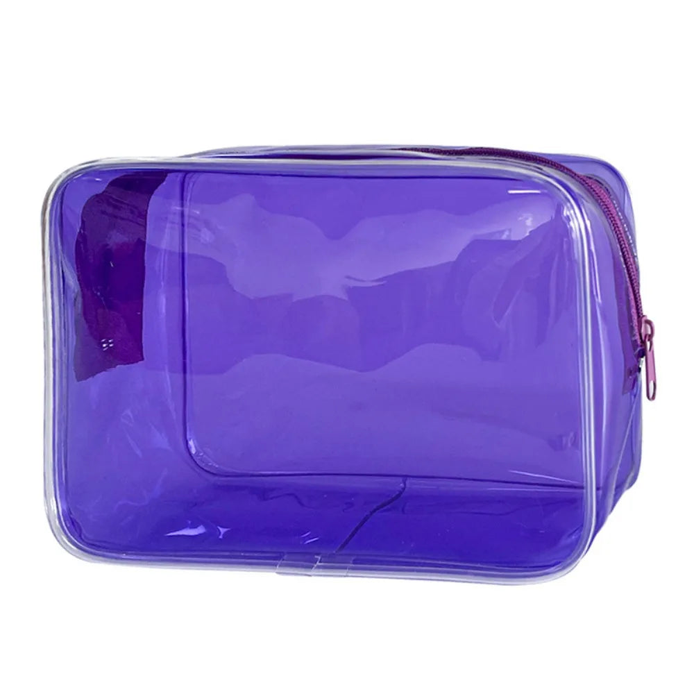 A transparent purple PVC travel makeup bag with a zipper closure.