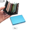 يد تمسك بحامل بطاقات حماية RFID أسود يعرض عدة بطاقات هوية معدنية نحيفة، مع بطاقة زرقاء مرئية