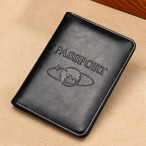 A black genuine leather passport holder with an embossed globe design is shown on a light brown surface.