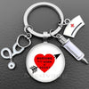 Silver keychain featuring a heart graphic with the text Nursing is a work of heart and a stethoscope charm