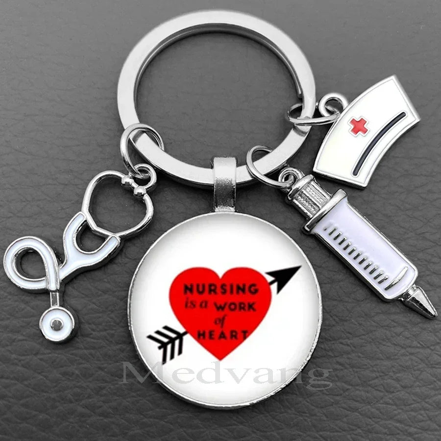 Silver keychain featuring a heart graphic with the text Nursing is a work of heart and a stethoscope charm