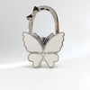 Silver foldable butterfly shaped handbag hook with a small flower detail