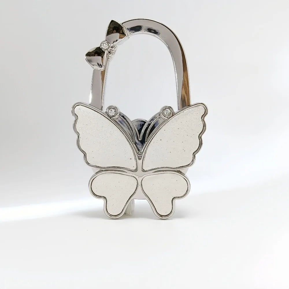 Silver foldable butterfly shaped handbag hook with a small flower detail