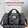 A black and white leopard print sports gym bag with a handle and zippered compartment.