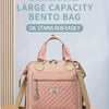 Sac Bento rose à division avec motif matelassé et anses en tan, exposé sur une surface en bois.