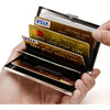 Eine Hand hält eine offene Metal-RFID-Kreditkarten-Wallet mit gestapelten Plastikkarten.