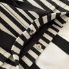 Gros plan d'un sac bandoulière en toile rayée noire et blanc cassé tendance.