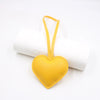 A yellow PU leather heart-shaped keychain attached to a white cylindrical object.