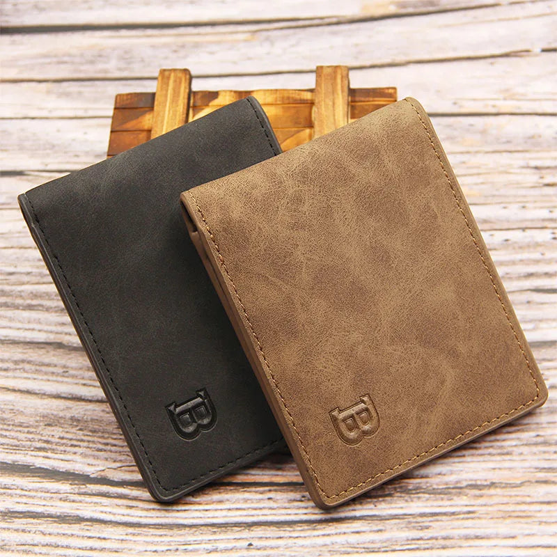 A dark gray and tan leather wallet is shown next to a wooden tray on a light wooden surface.