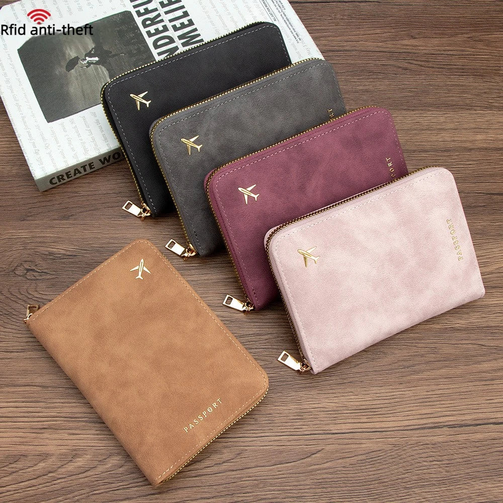 A collection of slim passport wallets in various colors including black, gray, and mauve, displayed on a wooden surface.
