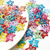 A collection of colorful vintage star hair clips and barrettes arranged on a white plate.