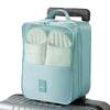 A light blue portable luggage shoe organizer bag with mesh pockets resting on a silver suitcase.