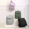 A collection of three insulated travel backpacks in lilac, olive green, and black resting on a white surface.
