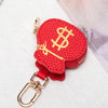 Bolsa de monedas con forma de corazón roja y signo de dólar dorado en llavero de plata.