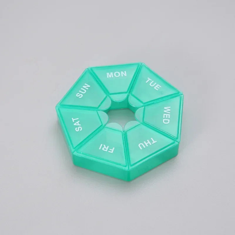 A teal weekly pill organizer divided into seven sections labeled SUN, MON, TUE, WED, THU, FRI, SAT, and a separate section fo