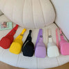 A collection of colorful nylon crossbody bags for kids displayed on a white, fluffy surface.