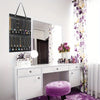 A white dresser with a mirror and wall-mounted jewelry organizer featuring various necklaces and earrings.