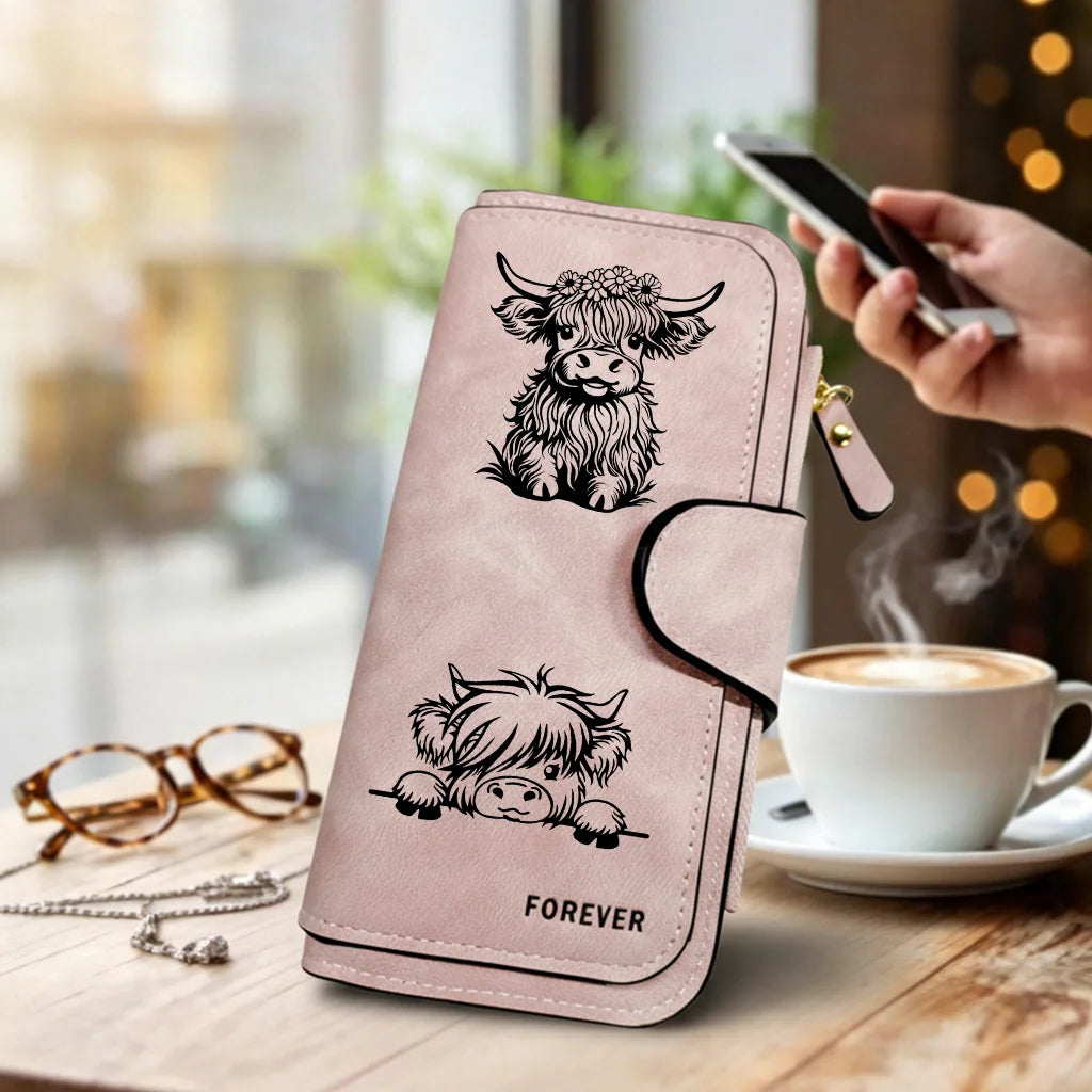 Cartera de cuero PU rosa con silueta negra de cabeza de vaca y la palabra forever, sobre una mesa de madera.