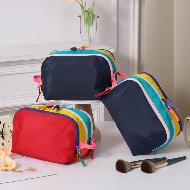 A set of lightweight travel makeup bags in various dopamine colors including blue, green, pink, and red.