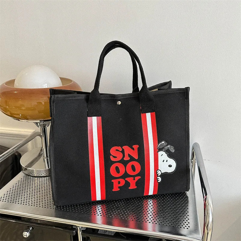 Black canvas shoulder bag featuring red and white stripes and a Snoopy cartoon design.