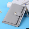 A light gray PU leather mini card holder wallet with a zipper and a gold-colored clasp is shown on a blue background.