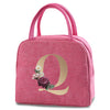 A pink insulated canvas lunch bag featuring a large gold letter Q design.