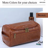 A brown leather toiletry bag with brass clasps is shown next to a bottle and a small grooming tool.