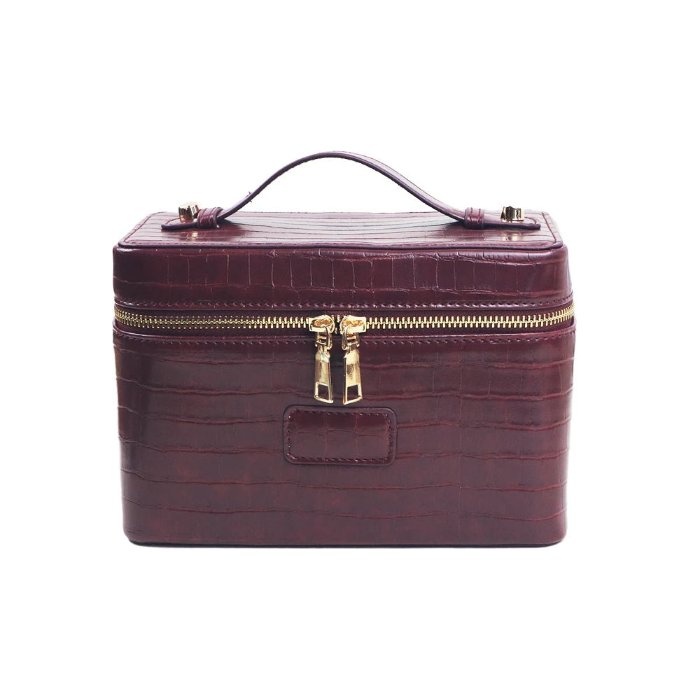 A maroon PU leather makeup bag with a gold zipper and leather trim.