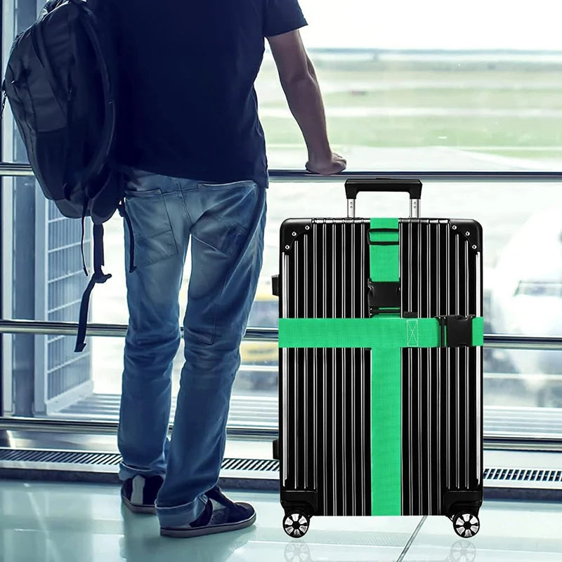A person stands next to a black rolling suitcase with bright green straps in a modern airport setting.
