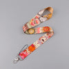 A patterned fabric lanyard with a key ring attached, featuring floral and animal designs.