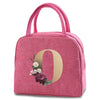 A pink insulated canvas lunch bag featuring a gold letter O design with small floral accents.