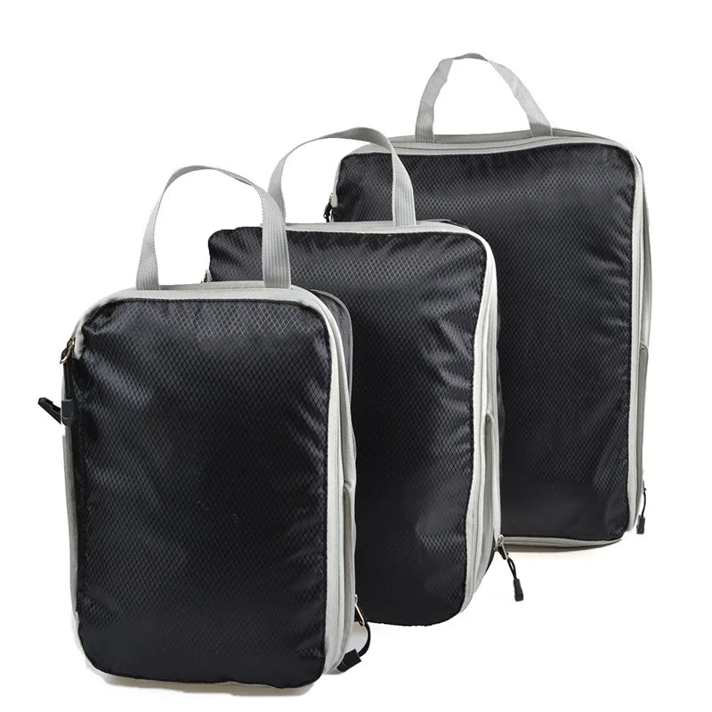 A set of black and gray reusable compression packing cubes with fabric handles.