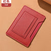 Portefeuille de voyage fin rouge pour passeport et documents sur fond beige.